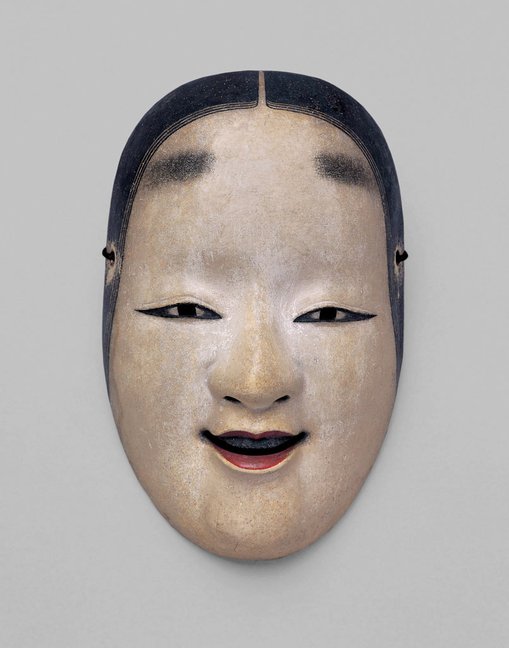 Nō mask Ko-omote, Edo period, 17th centuryNational Noh Theatre
This mask portrays the features of a sweet young woman. One trait of the ko-omote mask is the three strands of hair that fall naturally from the top of the forehead. This is mask is used for various young female roles in different plays depending on the wishes of the actor.